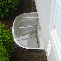 A vinyl basement window and covered window well in Forks