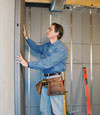 Insulated basement wall panels being placed against a concrete foundation wall in Port Orchard
